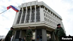 Pasukan pro-Russia berjaga di depan gedung parlemen Krimea di Simferopol (6/3).