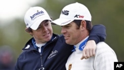 Rory McIlroy (L) of Northern Ireland and Louis Oosthuizen of South Africa talk at the 18th green during the final practice round for the British Open golf championship at Royal St George's in Sandwich, southern England, July 13, 2011