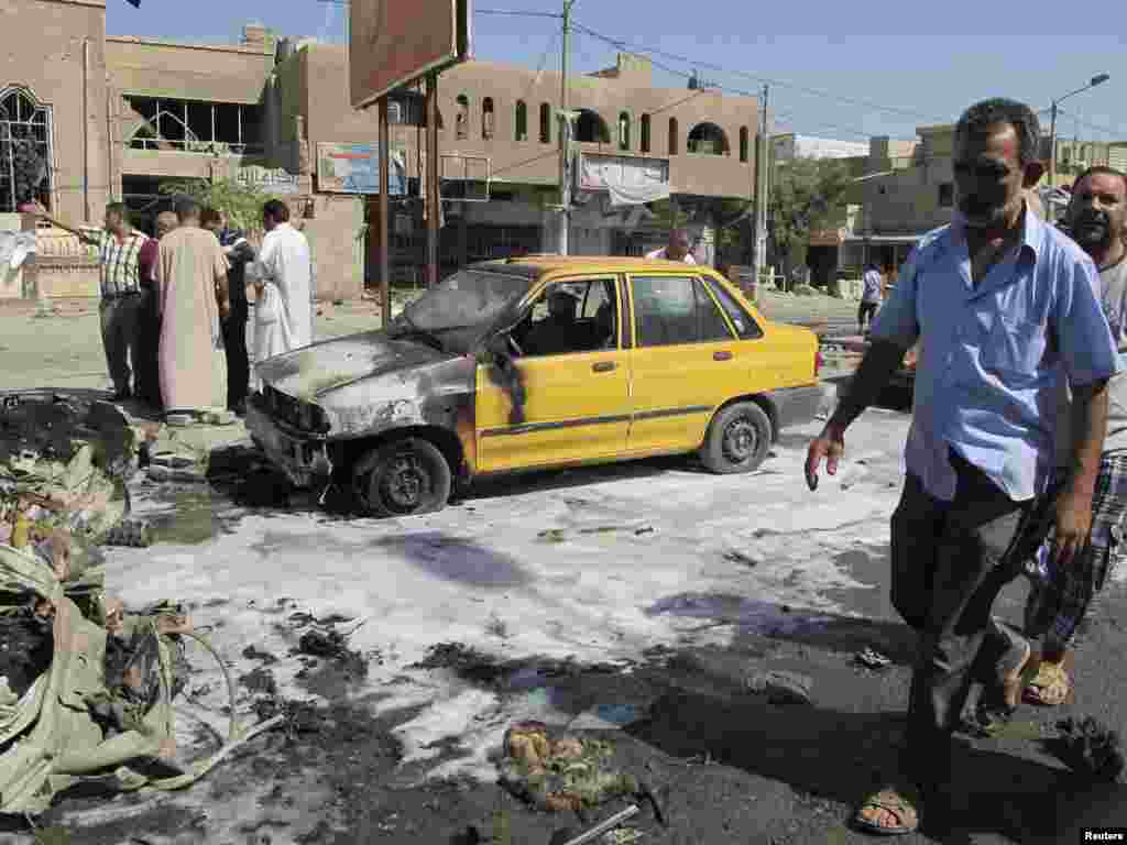 A man walks near the site of a car bomb attack in Baghdad's Hurriya District, August 28, 2013.