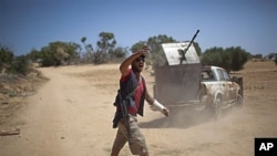 A rebel fighter gives orders to comrades at the front line between the rebels and Moammar Gadhafi forces, 25 km west from Misrata, Libya, May 26, 2011