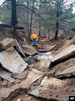 About 75 feet (23 meters) of pavement in the San Jacinto Mountains collapsed near Idyllwild, Calif., Feb. 15, 2019, from storms. Rainwater continues to drain Friday from California's saturated landscapes, and road crews in parts of Colorado, Montana and Wyoming are clearing roads.