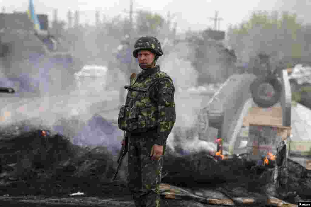 ایک فوجی تباہ شدہ چیک پوسٹ کے قریب کھڑا ہے۔