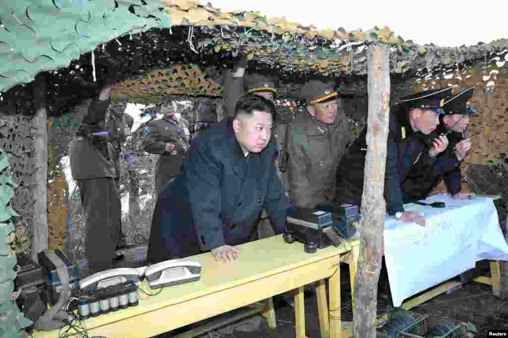 2013年3月25日，在这张官方的朝中社公布的照片中，朝鲜领导人金正恩观看朝鲜人民军士兵参加演习。