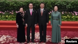 FILE - Vietnam's President Tran Dai Quang, second left, and his wife Nguyen Thi Hien, left, pose with Chinese President Xi Jinping and his wife Peng Liyuan during a welcome ceremony for leaders attending the Belt and Road Forum, at the Great Hall of the People in Beijing, May 14, 2017.