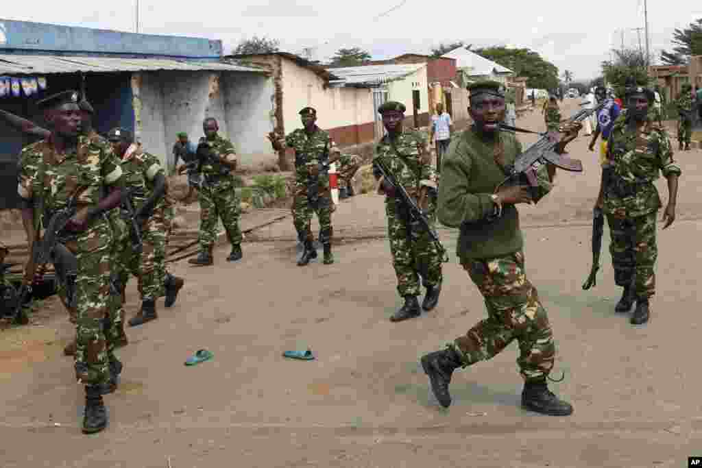 Des soldats tirent en l&#39;air pour disperser des manifestants qui ont acculé Jean Claude Niyonzima un membre présumé de la milice Imbonerakure de la jeunesse du parti au pouvoir dans un égout dans le quartier de Cibitoke de Bujumbura, au Burundi, jeudi 7 mai 2015.