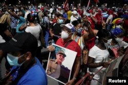 A man holds an image of Cuba's former President and First Secretary of the Communist Party Raul Castro during a rally amid concerns about the spread of the coronavirus disease (COVID-19) in Havana, Cuba, July 17, 2021. REUTERS/Alexandre Meneghini
