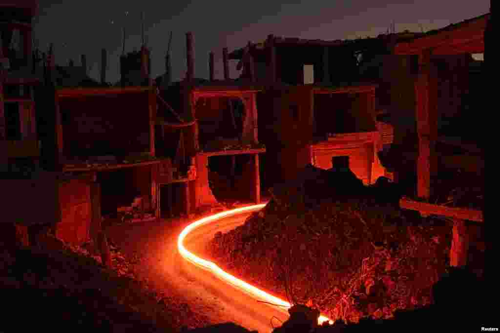 Damaged buildings are pictured at night in the rebel-held area, in the city of Deraa, Syria, July 15, 2017.