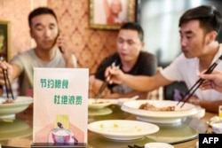 FILE - A sign encouraging people not to waste food is seen at a restaurant in Handan in China's northern Hebei province on August 13, 2020.