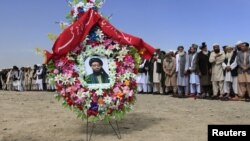 A portrait of former Taliban minister Maulvi Arsala Rahmani, a senior member of the High Peace Council, is seen as officials and mourners attend his funeral in Kabul. 