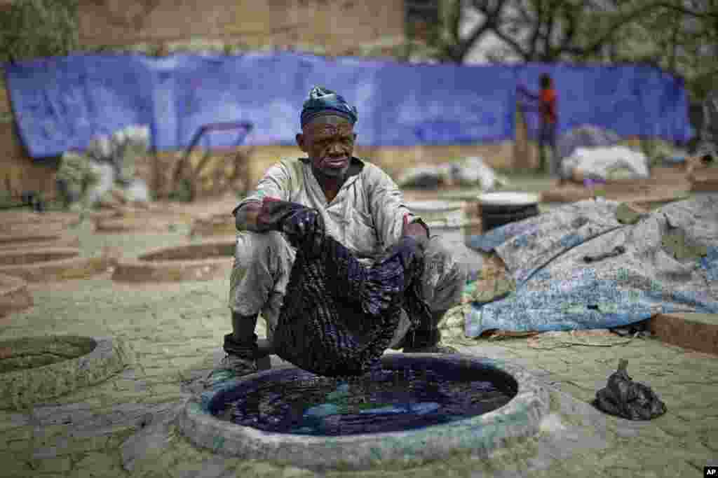 나이지리아 북부 카노의 코파르 마타에서 남성이 전통 방식으로 옷에 물을 들이고 있다.