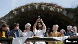 Actors raise a challice during a Last Supper recreation as part of Easter festivities in the Czech Republic city of Ceska Lipa April 19, 2014.