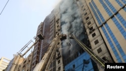 فائر فائٹرز ڈھاکہ کی کیثر منزلہ عمارت میں لگی آگ بچھانے کی کوشش کر رہے ہیں۔ 28 مارچ 2019