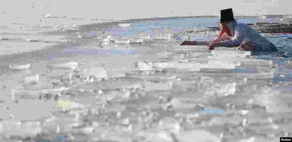 지난 14일(현지시간) 독일 베를린에서 진행된 카니발 참가자가 호수 얼음을 깨고 수영한 뒤 나오고 있다.&nbsp;