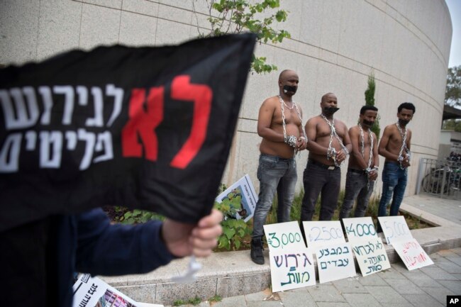 FILE - African migrants wear chains to represent slavery during a demonstration in Tel Aviv, Israel, April 3, 2018.