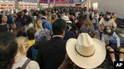 En esta imagen proporcionada por Austin Boschen, gente esperando a pasar la aduana en el Aeropuerto Internacional de Dallas Fort Worth en Grapevine, Texas, el sábado 14 de marzo de 2020. Saturday, March 14, 2020. 