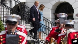 El presidente de EE.UU., Donald Trump, y la primera dama Melania Trump bajan del balcón Truman en Washington, el lunes 22 de abril de 2019, durante la Carrera Anual de Huevos de Pascua de la Casa Blanca.