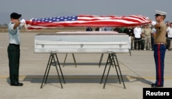 U.S. military personnel drape a U.S. flag over a coffin containing human remains believed to be a U.S serviceman missing in action during the Vietnam War, at a repatriation ceremony at Hanoi's Noi Bai airport on Dec. 9, 2008.