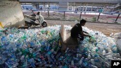 Archivo - Junio 2018 - Un trabajador indio separa botellas de plástico antes de enviarlas a reciclar.