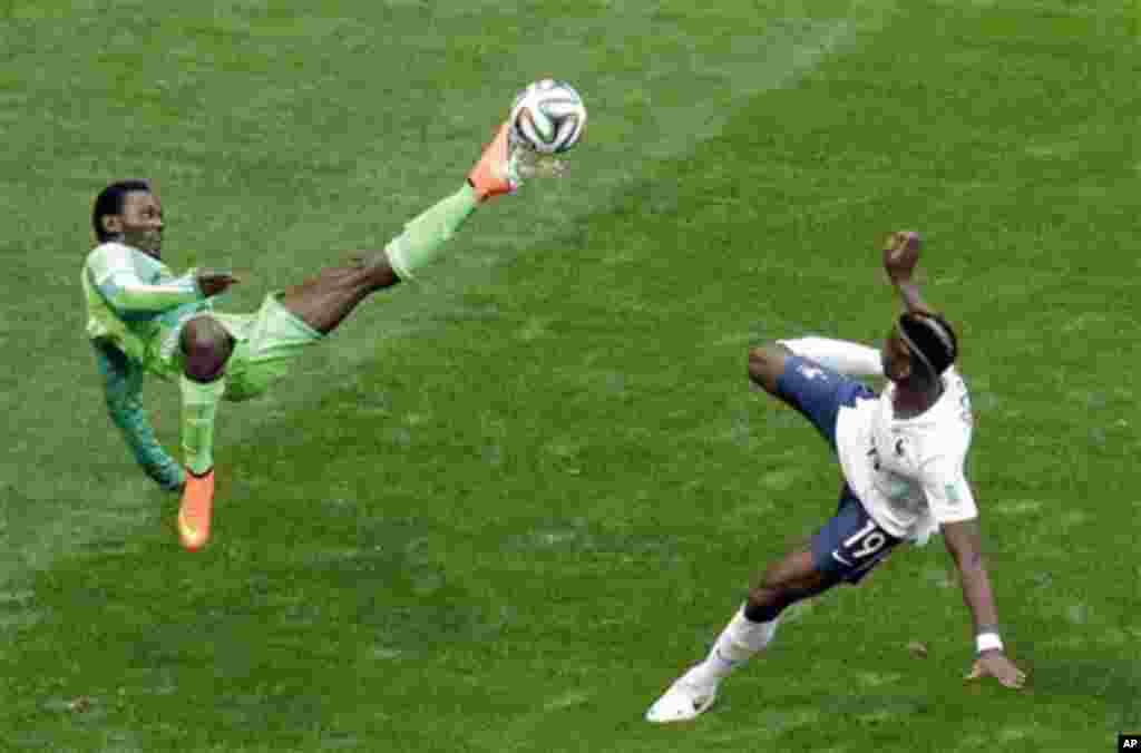 Nigeria's Juwon Oshaniwa, left, and France's Paul Pogba challenge for the ball during the World Cup round of 16 soccer match between France and Nigeria at the Estadio Nacional in Brasilia, Brazil, Monday, June 30, 2014. (AP Photo/Hassan Ammar)