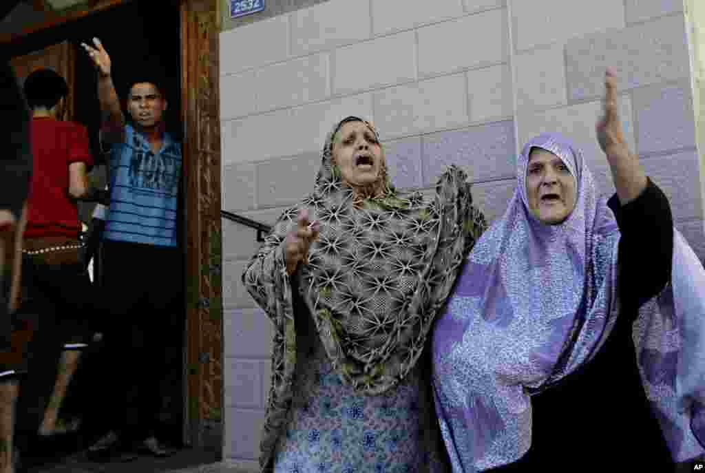 Palestinians overcome by emotion arrive at a mosque for shelter after an Israeli strike hit Gaza City, northern Gaza Strip, Thursday, Aug. 21, 2014.