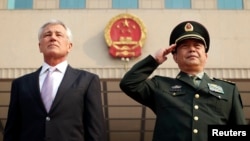FILE - U.S. Defense Secretary Chuck Hagel (L) and his Chinese counterpart Chang Wanquan (R) listen to the Chinese national anthem during a welcoming ceremony at the Chinese Defense Ministry headquarters, prior to their meeting in Beijing, April 8, 2014.
