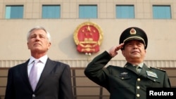 FILE - US Defense Secretary Chuck Hagel (L) and his Chinese counterpart Chang Wanquan (R) listen to the Chinese national anthem during a welcoming ceremony at the Chinese Defense Ministry headquarters, prior to their meeting in Beijing, April 8, 2014.