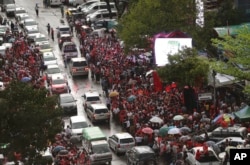 Supporters of Myanmar's National League for Democracy party, gather outside the NLD headquarters in the rain in Yangon, Myanmar, Nov. 9, 2015.