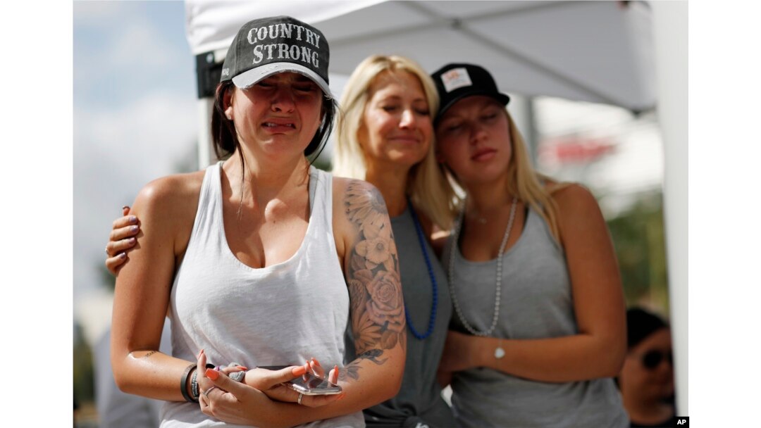 Desde la izquierda, Michaela Stilwell, Melinda Stilwell y Taylor Curtis asisten a un servicio de oración en el aniversario del tiroteo masivo del 1 de octubre de 2017, el lunes 1 de octubre de 2018 en Las Vegas. Michaela Stilwell y Taylor Curtis asistieron al festival de música country el año pasado y regresaron a Las Vegas para el aniversario. (AP Photo / John Locher)