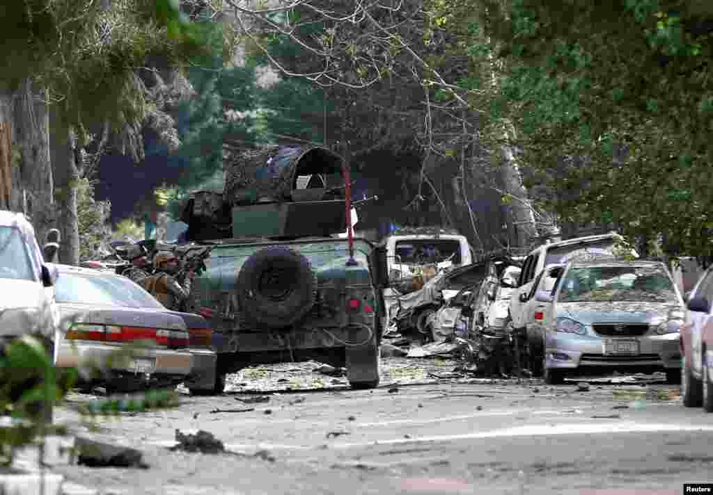 Afghan security forces take position during a Taliban car bomb-and-gun attack against a U.S.-funded international relief organization, in Kabul, Afghanistan.