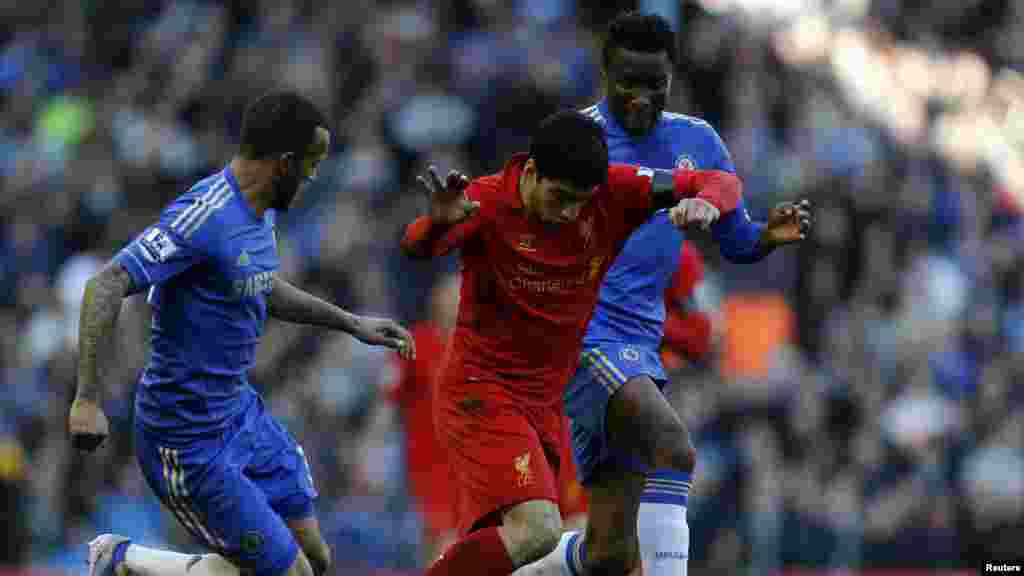 Chelsea's John Obi Mikel (R) and Ryan Bertrand (L) challenge Liverpool's Luis Suarez during their English Premier League soccer match at Anfield in Liverpool, northern England, April 21, 2013.