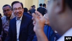 Malaysian Opposition leader Anwar Ibrahim listens (2nd L) to his friend during a break at the federal court in Putrajaya, Oct. 30, 2014.