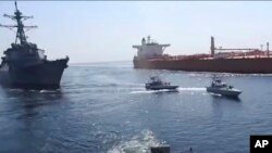 이란 국영 TV가 지난 3일 공개한 오만해 영상에서 이란 혁명수비대 선박들이 미 해군 함정(왼쪽)과 베트남 선적 유조선(오른쪽) 사이를 기동하고 있다.