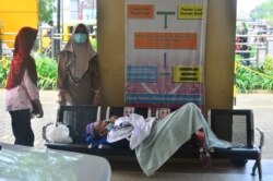 Seorang pasien harus menunggu di sebuah rumah sakit di Kudus, Jawa Tengah akibat lonjakan kasus COCID-19 di sana.