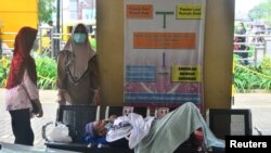 Seorang pasien terbaring di bangku saat mengantri untuk dirawat di ruang gawat darurat RSUD Dr. Loekmono Hadi, di tengah pandemi COVID-19 di Kudus, Provinsi Jawa Tengah, 2 Juni 2021. (Foto: Reuters)