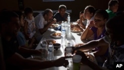 Cubans eat dinner, March 25, 2017, at the migrant shelter "Casa del Migrante" in Nuevo Laredo, Mexico, across the border from Laredo, Texas. Some Cubans have been stuck here since then-President Barack Obama on Jan. 12 ended the so-called "wet foot, dry foot" policy. 