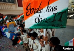 Students cheer as they raise flags to celebrate after India shot down one of its satellites in space with an anti-satellite missile in a test, inside their school premises in Ahmedabad, India, March 27, 2019.