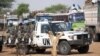 In this July 14, 2011 photo released by the African Union/UN Hybrid operation in Darfur (UNAMID), UNAMID Rwandan troops escort returnees during a repatriation operation for more than 200 displaced families, north Darfur, Sudan. 