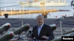 Israel's Prime Minister Benjamin Netanyahu speaks to the media in front of a display of M302 rockets, found aboard the Klos C ship, at a navy base in the Red Sea resort city of Eilat on March 10, 2014. 