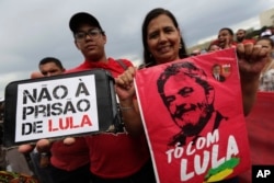 Demonstrators carry signs written in Portuguese that read "No Prison for Lula," left, and "I'm with Lula," during a protest in support of Brazil's former President Luiz Inacio Lula da Silva, in Brasilia, Brazil, April 4, 2018.