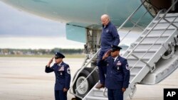 President Joe Biden catches his balance as he walks down the stairs of Air Force One as he arrives at Detroit Metropolitan Wayne County Airport to join striking United Auto Workers on the picket line, Tuesday, Sept. 26, 2023, in Romulus, Mich. 