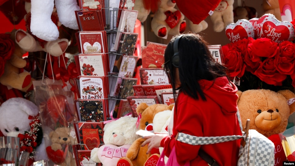 Una mujer camina junto al puesto de un vendedor ambulante que vende peluches y rosas antes del Día de San Valentín en San Gwann, Malta, el 13 de febrero de 2025. 