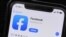 FILE - The Facebook application is displayed on a mobile phone at a store in Chicago, July 30, 2019.