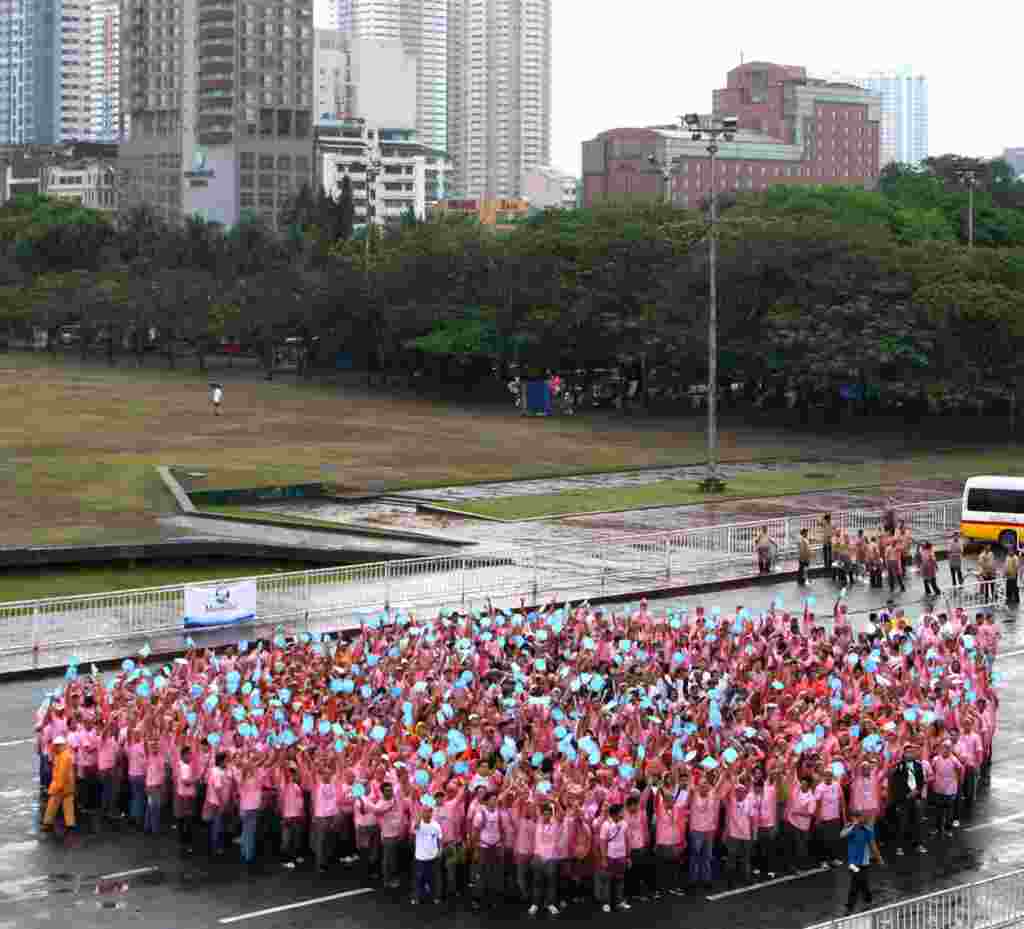 Cientos de personas intentan formar una gota de agua al frente de la Tribuna de Quirino en Manila, Filipinas, como parte de la celebración del Día Mundial del Agua.