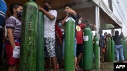 Relatives of COVID-19 patients queue for long hours to refill their oxygen tanks in Manaus, Amazonas state, on January 19, 2021.