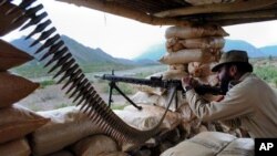 A Pakistani paramilitary soldier prepares to fire during a military operation against militants in Pakistan's Khurram tribal region, Saturday, July 9, 2011