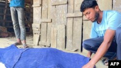 A man covers the body of an unnamed ethnic Rohingya refugee, victim to a mortar shell at Bangladesh's Ghumdum border in Bandarban district on February 5, 2024.