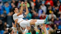 Alvaro Arbeloa de Real Madrid est soulevé par ses coéquipiers après une victoire de leur équipe contre Valencia lors d’un match de la ligue espagnole au stade Santiago Bernabeu à Madrid, Espagne, 8 mai 2016 . (AP photo / Paul White)