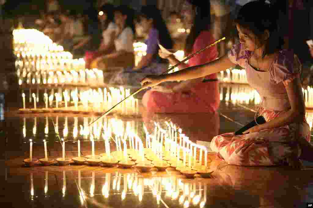 Buddhist devotees light candles during the full moon day of Tazaungmone, also known as the lighting festival, at a pagoda in Yangon, Myanmar.