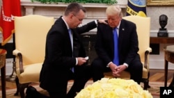 Trump American PastorLe président Donald Trump prie avec le pasteur américain Andrew Brunson au Bureau ovale de la Maison-Blanche, à Washington, le 13 octobre 2018.