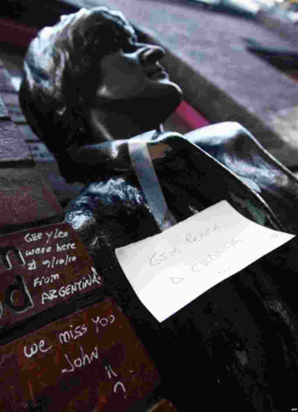 A note left on a statue of John Lennon outside the Cavern Pub in Mathew Street, Liverpool, England, Wednesday Dec. 8, 2010. Beatles fans will mark the 30th anniversary of John Lennon's death with a candlelit vigil at the city's European Peace Monument, wh